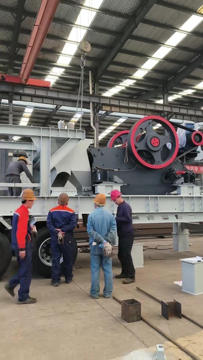 Assembly workers building a mobile jaw crusher in our factory workshop